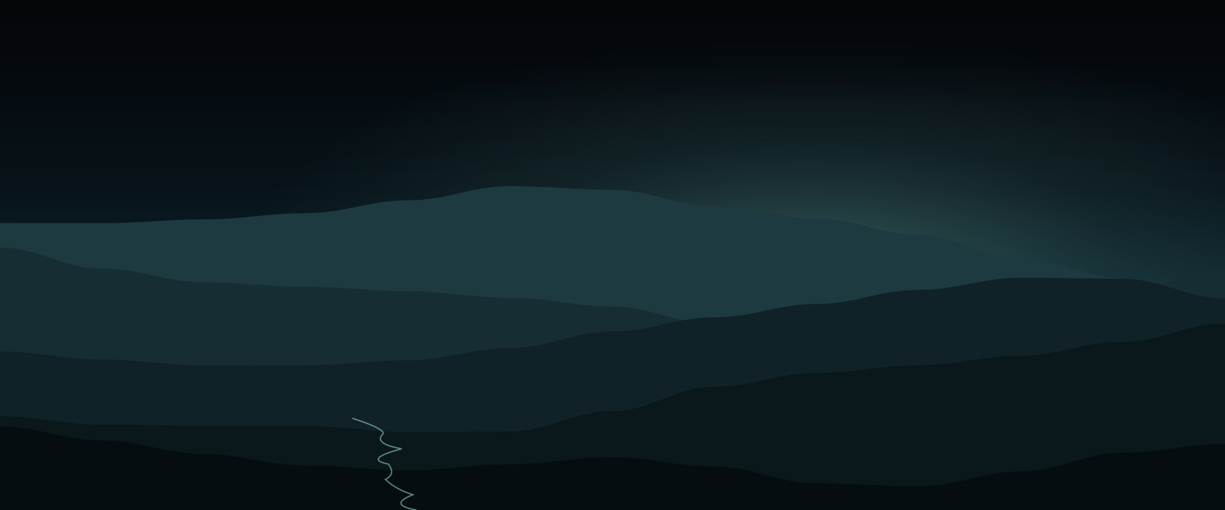 Layered ridgelines receding into haze at dusk.